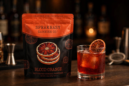 Dried blood orange slice garnish in a negroni beside the Speakeasy Garnishes blood orange pouch
